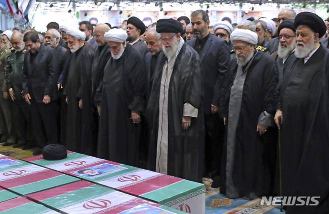 [테헤란=AP/뉴시스] 아야톨라 알리 하메네이(가운데) 이란 최고지도자가 22일(현지시각) 수도 테헤란에서 열린 고 에브라힘 라이시 대통령과 헬기 추락 사고 희생자들의 영결식에서 기도하고 있다. 2024.05.23.