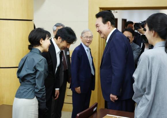 가수 이문세 부부와 인사하는 윤석열 대통령 - 윤석열 대통령이 22일 서울 서초구 대한민국학술원에서 열린 개원 70주년 기념식에서 행사를 마친 뒤 자연기초 분야 국민훈장 무궁화장을 받은 이상만 회원의 사위인 가수 이문세  부부와 인사하고 있다. 2024.5.22 대통령실통신사진기자단