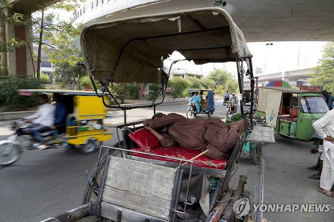 23일 파키스탄 라호르서 폭염속에 낮잠을 자는 말수레 운전자 [AP통신 연합뉴스 자료사진. 재판매 및 DB 금지]