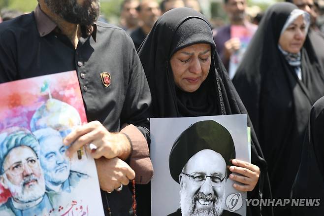 23일(현지시간) 이란 마슈하드 거리에 나서 라이시 대통령을 추모하는 시민들 [AFP=연합뉴스 자료사진. 재판매 및 DB 금지]