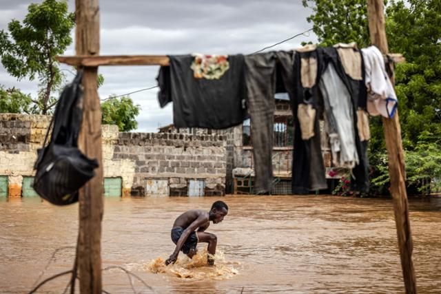 아프리카 케냐의 한 남성이 지난 8일 대규모 홍수가 발생한 가리사 지역에서 물살을 헤치며 대피하고 있다. 가리사=AFP 연합뉴스