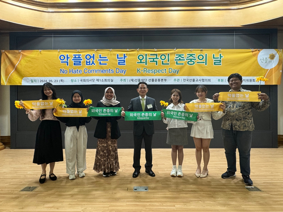 Min Byoung-chul, founder of the Sunfull Foundation and endowed chair professor at Chung-Ang University, center, and foreign students pose for a photo during the declaration ceremony for K-Respect Day at National Assembly members' office building in Yeouido, western Seoul, on Thursday. [SUNFULL FOUNDATION]