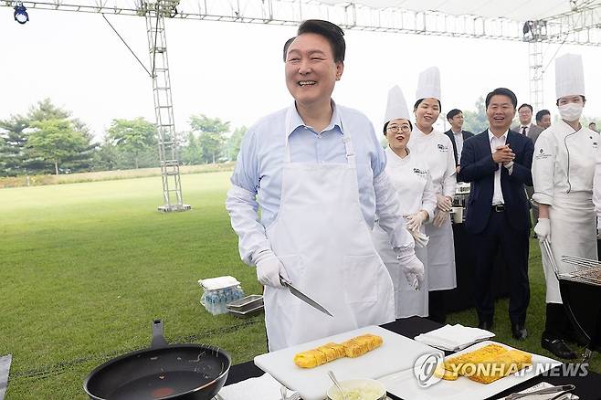 대통령의 저녁 초대, 앞치마 입은 윤석열 대통령 (서울=연합뉴스) 홍해인 기자 = 윤석열 대통령이 24일 서울 용산 대통령실 청사 잔디마당에서 열린 ‘대통령의 저녁 초대’  출입기자단 초청 만찬 간담회에서 계란말이를 만들고 있다. 2024.5.24 [대통령실 제공. 재판매 및 DB 금지] hihong@yna.co.kr