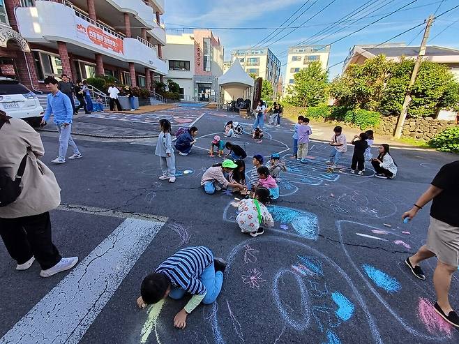 신효마을회관 앞에서 열린 바닥그림 행사에서 어린이들이 크레파스로 그림을 그리고 있다. 송호균 제공