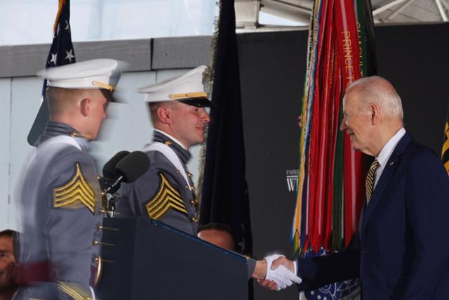 조 바이든(오른쪽) 미국 대통령이 25일 뉴욕주 웨스트포인트(미 육군사관학교) 졸업식에 참석해 축사를 마친 뒤, 한 졸업생에게 졸업장을 건네며 악수하고 있다. 웨스트포인트=AFP 연합뉴스