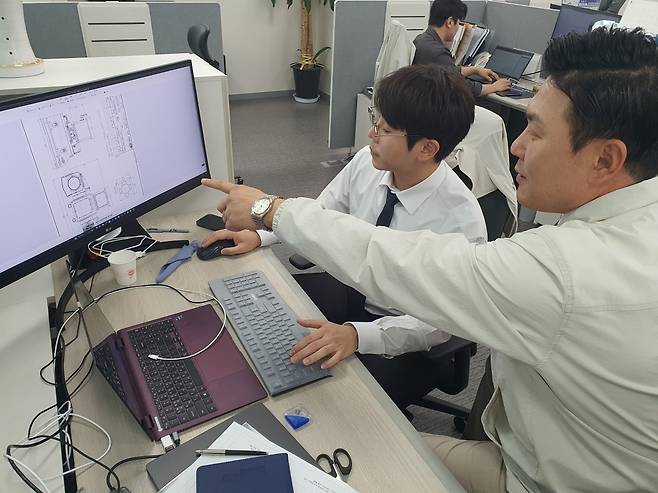 장원석 2본부장(오른쪽)이 이재광 과장과 국방 고성능 카메라 도면 확인을 하고 있다. 윤현주 기자