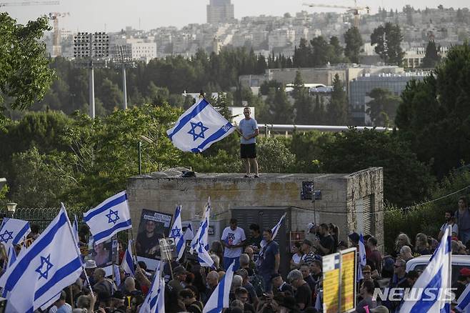 [예루살렘=AP/뉴시스] 5월 20일 이스라엘 예루살렘에 있는 이스라엘 의회(크네세트) 밖에서 가자지구에 억류된 인질들의 석방을 촉구하는 반정부 시위대가 국기를 흔들며 시위하고 있다. 2024.05.26.