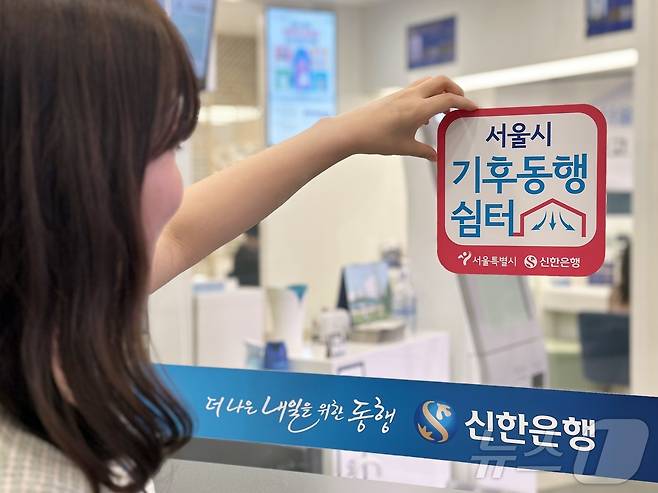 신한은행 시청점 입구에 기후동행쉼터 안내 현판을 붙이는 모습 (서울시 제공)