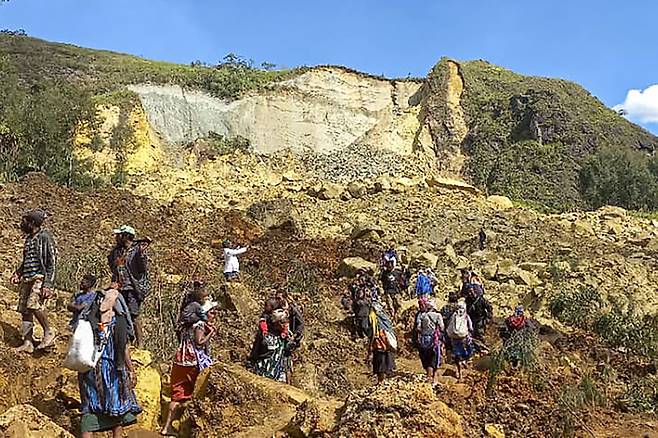 산사태가 일어난 파푸아뉴기니 얌발리 마을에서 26일(현지시간) 주민들이 실종자를 수색하고 있다. AP연합뉴스