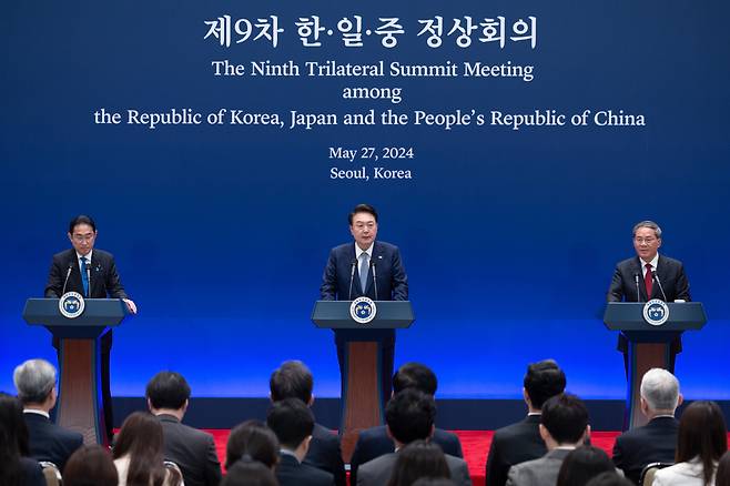 President Yoon Suk Yeol (center) speaks during a joint press briefing of the ninth trilateral summit with Japanese Prime Minister Fumio Kishida (left) and Chinese Premier Li Qiang at the former presidential office of Cheong Wa Dae in Seoul on Monday. (Yonhap)