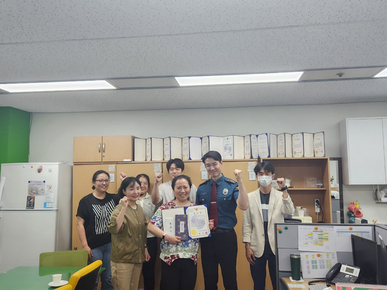 The Seoul Jungnang police officer, right, awarded 64-year-old public worker Cho Eun-kyung, center, an award and reward on May 20 for her work in preventing voice phishing scam. [SEOUL JUNGNANG POLICE PRECINCT]