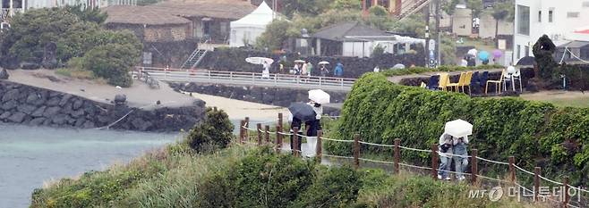 제주지역에 비가 내리는 지난 26일 오후 제주시 애월읍 한담해안산책로에서 관광객들이 우산을 쓰고 산책하고 있다. /사진=뉴스1