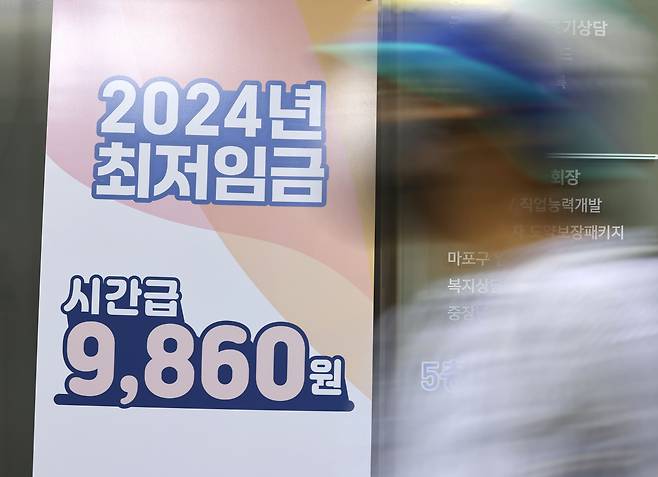 13일 서울의 한 고용복지플러스센터에 2024년 최저임금 입간판이 설치돼 있다. [연합]