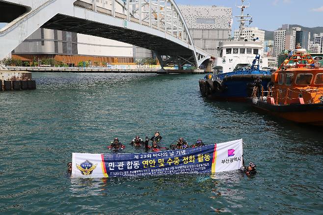 28일 바다의 날 기념 수중 정화활동 중 다이버들이 캠페인 현수막을 들고있다. 부산해양경찰서 제공