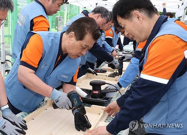 포스코그룹 대규모 봉사활동 '2024 글로벌 볼런티어 위크' 기간인 28일 장인화(왼쪽) 포스코그룹 회장이 포스코 재능봉사단원들과 함께 포항 대송면 제내리에서 마을 어르신들을 위한 밥상을 만드는 목공 봉사활동을 하고 있다. 연합뉴스