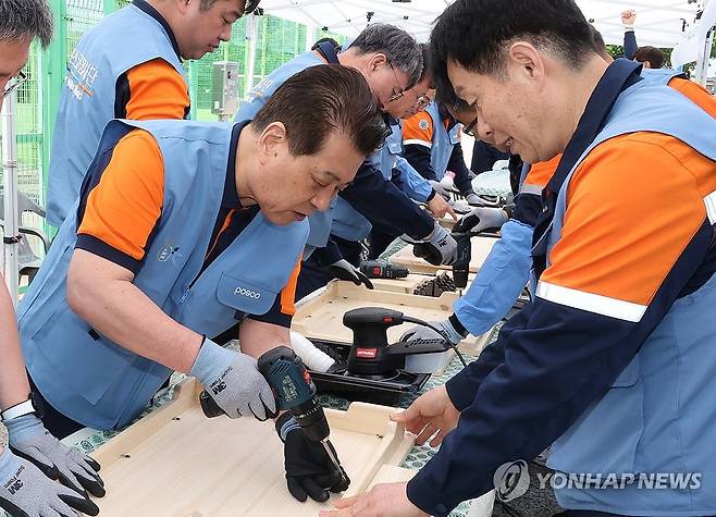 목공 봉사활동 하는 장인화 회장 (서울=연합뉴스) 포스코그룹 대규모 봉사활동 '2024 글로벌 볼런티어 위크' 기간인 28일 장인화 포스코그룹 회장이 포스코 재능봉사단원들과 함께 포항 대송면 제내리에서 마을 어르신들을 위한 밥상을 만드는 목공 봉사활동을 하고 있다. 2024.5.28 [포스코홀딩스 제공. 재판매 및 DB 금지] photo@yna.co.kr