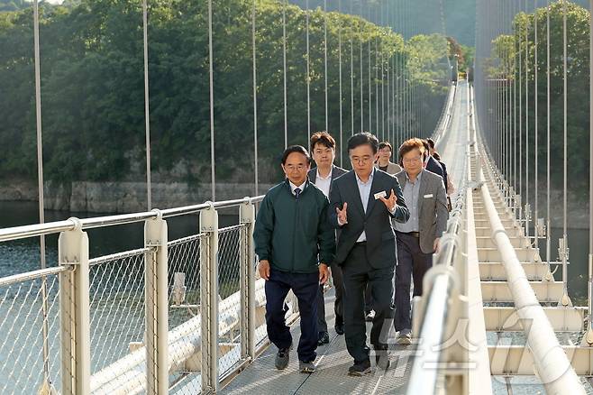 전북자치도 임실군을 방문한 진교훈 서울 강서구청장(오른쪽)이 심민 임실군수와 옥정호 출렁다리를 걷고 있다.(임실군제공)2024.5.29/뉴스1