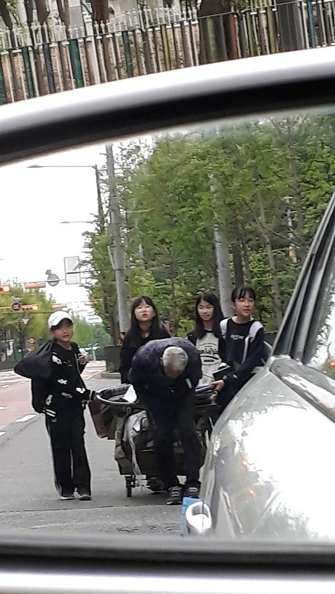 경기 안산시 관산초등학교 5학년 여학생 4명이 지난달 23일 폐지를 수집하는 할아버지의 수레를 뒤에서 밀어주고 있다. 안산시 제공