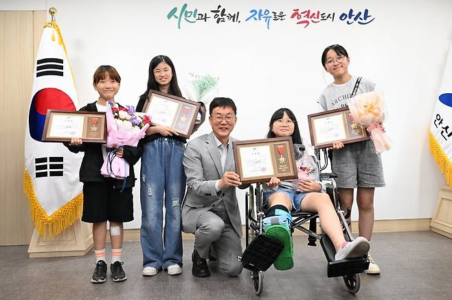 이민근 안산시장이 폐지를 수집하는 할아버지를 도운 관산초등학교 5학년 여학생 4명을 28일 시청으로 초대해 표창장을 수여한 뒤 기념사진을 찍고 있다. 안산시 제공