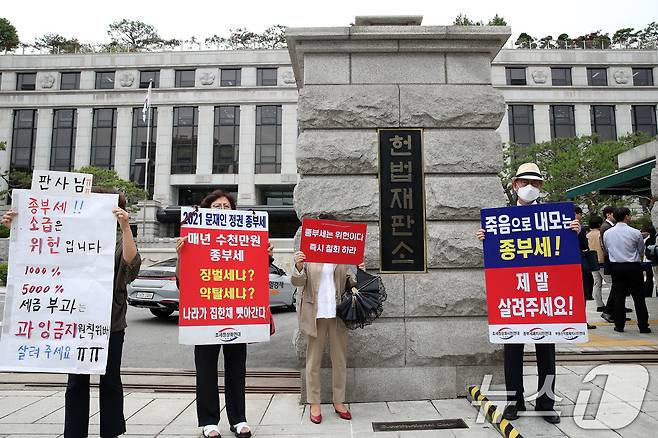 조세정의시민연대 등 종부세 폐지를 촉구하는 시민들이 30일 서울 종로구 헌법재판소 대심판정에서 열린 5월 심판사건 선고를 앞두고 피켓시위를 하고 있다. 헌재는 이날 ‘수신료 분리징수’ 헌법소원 선고, '헌정사 첫 검사 탄핵심판' 선고를 비롯해 대체복무제와 종부세 위헌 여부 등에 대해 결론낸다. 2024.5.30/뉴스1 ⓒ News1 오대일 기자