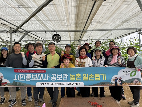 청주시 공보관 직원과 시민홍보대사 등 20여명이 30일 흥덕구 오송읍 한 농장의 일손을 돕고 기념 촬영을 하고 있다. [사진=청주시]