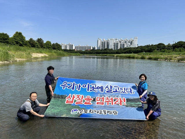 전북환경운동연합 관계자들이 29일 전주 삼천 마전교 주변 물속에서 기자회견을 열고 과도한 하천 준설 작업을 멈추라고 주장하고 있다. 전북환경운동연합 제공