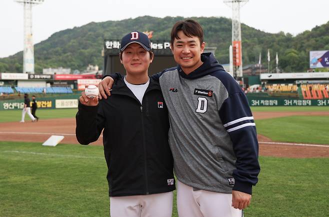 왼쪽부터 두산 베어스 투수 김택연과 타자 김재환. 4월 28일 대전 한화 이글스전에서 김택연이 프로 데뷔 첫 승을 거두자 함께 기념촬영하고 있다. 두산 베어스 제공