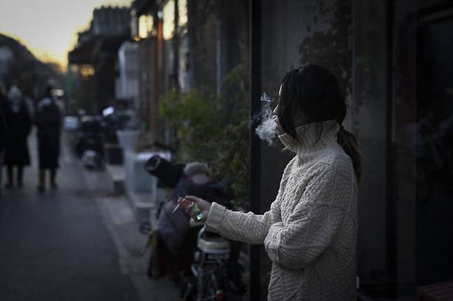 중국 베이징의 한 거리에서 시민이 담배를 피우고 있다. (사진=AFP)