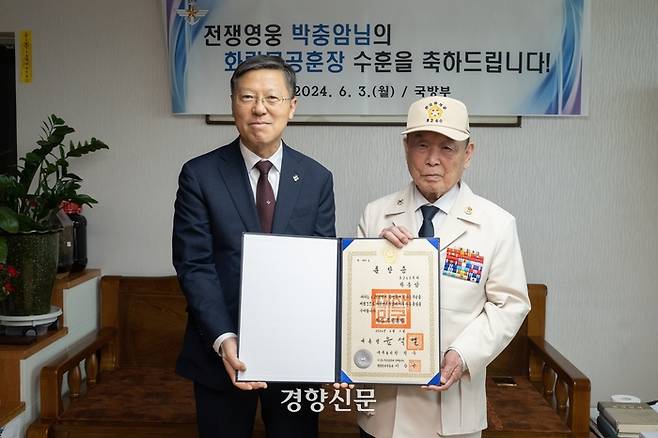 6·25전쟁 참전용사 박충암씨(오른쪽)가 경기도 광명시의 자택에서 오영대 국방부 인사기획관으로부터 화랑무공훈장을 전달받고 기념사진을 찍고 있다. 국방부 제공