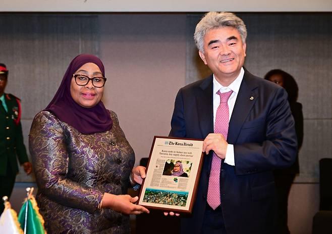 Daewoo Engineering & Construction Chairman Jung Won-ju (right), who doubles as chairman of Herald Media Group, presents a plaque of a Korea Herald article on Tanzania and its economy to Tanzanian President Samia Suluhu Hassan at a meeting held in Seoul on Sunday. (Park Hae-mook/The Korea Herald)