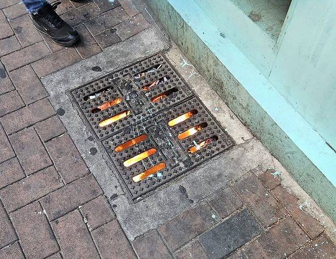 담배꽁초에 남은 불씨로 하수구에서 불이 활활 타오르고 있는 모습. /엑스