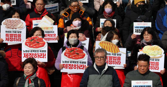 지난 1월 29일 오전 서울 여의도 국회 본청 앞 계단에서 열린 노점상 생계보호특별법 제정 촉구대회 및 기자회견에서 참석자들이 피켓을 들고 있다. 뉴시스