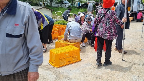 봉화군 어르신 효(孝) 한마당 행사에 참석한 지역 주민들이 부족한 음식으로 점심을 거르며 일부는 집으로,  일부는 삼삼오오 모여 뙤약볕 구석에 쪼그리고 앉아 있다(독자 제공)