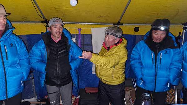 베이스캠프에서 엄홍길 대장(노란색 패딩)과 한국-네팔 대원들이 하이캠프 설치와 장비 보급. 그리고 정상 등정에 대한 대화를 나누고 있다.