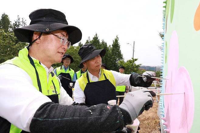 NH투자증권이 5일 농협경제지주 축산경제와 함께 농협 안성팜랜드에서 축산환경개선 사업 행사를 진행했다. 안병우 축산경제 대표(왼쪽)와 윤병운 NH투자증권 대표(오른쪽)가 벽화를 그리고 있다. NH투자증권