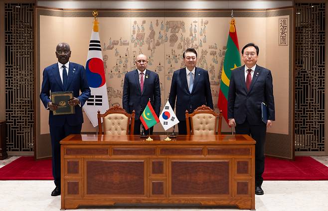 윤석열 대통령이 5일 서울 용산 대통령실 청사에서 무함마드 울드 가주아니 모리타니아 대통령과 한-모리타니아 무역투자촉진프레임워크(TIPF) 양해각서(MOU) 서명식에 배석해 정인교 산업통상자원부 통상교섭본부장과 무함마드 살렘 울드 메르주그 모리타니아 외교장관의 서명 뒤 기념촬영을 하고 있다. [산업통상자원부 제공]