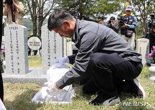 [서울=뉴시스] 황준선 기자 = 5일 오전 서울 동작구 국립서울현충원에서 열린 호국의 형제 안장식에서 유가족이 故 전병섭 하사의 유해를 하관하고 있다. 2024.06.05. hwang@newsis.com