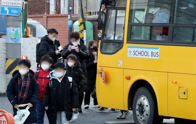 지난해 1월 30일 오전 서울 광진구의 한 초등학교 학생들이 마스크를 착용한 채 통학버스에서 내리고 있다. 정부는 이날 0시부터 대중교통과 의료시설 등을 제외한 실내에서 마스크 착용 의무를 권고로 조정했다. 뉴스1