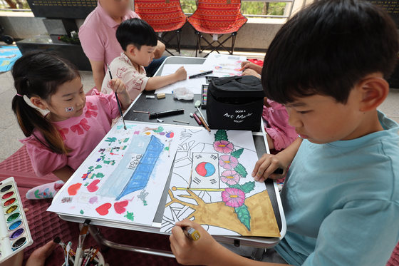 Children color pictures to commemorate Memorial Day during a drawing contest held at the War Memorial of Korea in Yongsan District, central Seoul, on Thursday. [YONHAP]