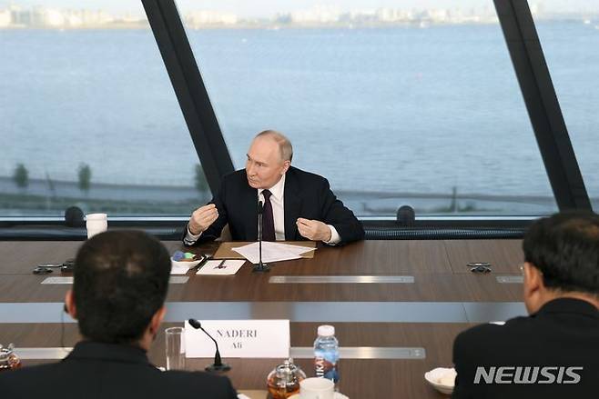 [상트페테르부르크=AP/뉴시스] 블라디미르 푸틴 러시아 대통령이 5일(현지시각) 러시아 상트페테르부르크에 위치한 상트페테르부르크 국제경제포럼(SPIEF) 부스에서 국제 통신사 간부들과 간담회 하고 있다. 2024.06.06.