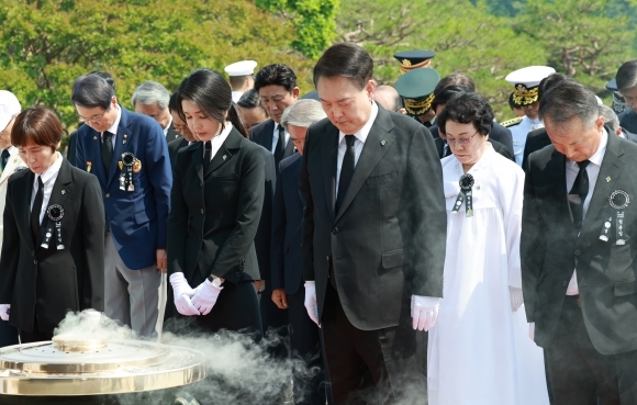 윤석열 대통령과 김건희 여사가 6일 서울 동작구 국립서울현충원에서 열린 제69회 현충일 추념식에서 현충탑에 참배하며 묵념하고 있다. 연합뉴스