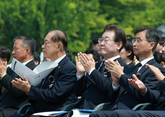 황우여 국민의힘 비상대책위원장과 이재명 더불어민주당 대표가 6일 서울 동작구 국립서울현충원에서 열린 제69회 현충일 추념식에 참석해 국가유공자들의 공로에 박수 보내고 있다. 뉴시스