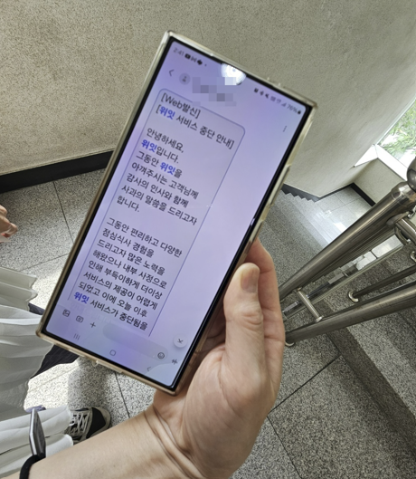 5일 서울 마포구 위잇 사무실 앞에서 만난 피해자 A씨가 위잇이 보낸 서비스 중단 문자를 보여주고 있다. [사진=이지은 기자]