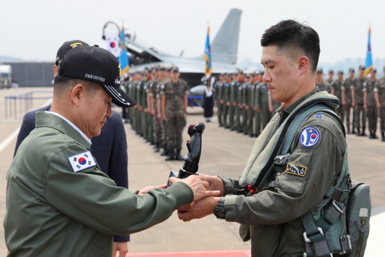 7일 경기 수원시 공군 10전투비행단에서 열린 F-4 팬텀 퇴역식에서 마지막 비행 임무를 마친  팬텀 전투기 조종사가 신원식(왼쪽) 국방부 장관에게  55년 간 팬텀의 영공수호 임무 종료를 보고하며 팬텀 조종간을 전달하고 있다. 사진공동취재단／연합뉴스