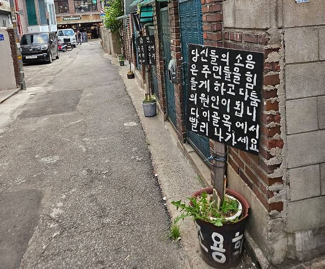 서울 합정동 한 골목에 세워진 ‘호소문’. ‘골목에서 빨리 나가달라’는 표지판이 4개나 있었다. /이미지 기자