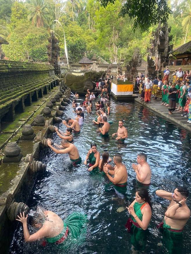 띠르따엠풀에서 관광객들이 성수에 몸을 씻고 있다.