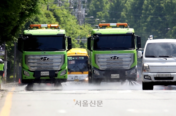 전국 대부분 지역에 초여름 날씨가 이어지고 있는 23일 광주 북구청 기후환경과 직원들이 일곡동의 일대 도로에서 살수차를 이용해 도로에서 올라오는 지열을 식히고 있다. 북구는 4개구간에 걸쳐 폭염 발생시 살수차를 운영해 나갈 계획이다. 2024.5.23 광주 북구청 제공