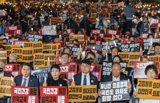 임현택(앞줄 가운데) 대한의사협회장을 비롯한 의사 등 관계자들이 지난 5월 30일 오후 서울 중구 덕수궁 대한문 앞에서 의사협회 주최로 열린 대한민국 정부 한국 의료 사망선고 촛불집회에 참석해 구호를 외치고 있다. [연합뉴스]