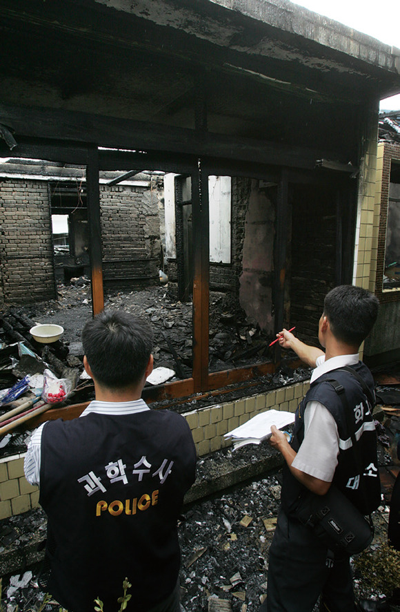 2005년 8월19일 화재 현장에서 경찰과 소방관이 현장감식을 하고 있다. ⓒ연합뉴스