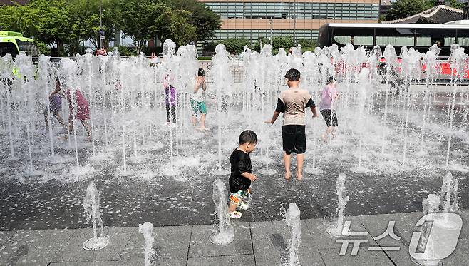 낮 기온이 30도 안팎으로 오른 9일 서울 세종대로 광화문광장 분수대를 찾은 아이들이 물줄기로 더위를 식히고 있다. 2024.6.9/뉴스1 ⓒ News1 이승배 기자